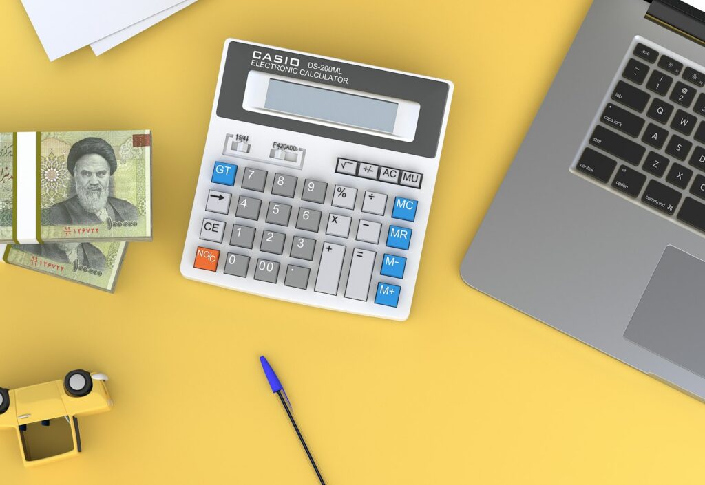 Backlinks kaufen oder Budget anders einsetzen: Taschenrechner neben einem Laptop