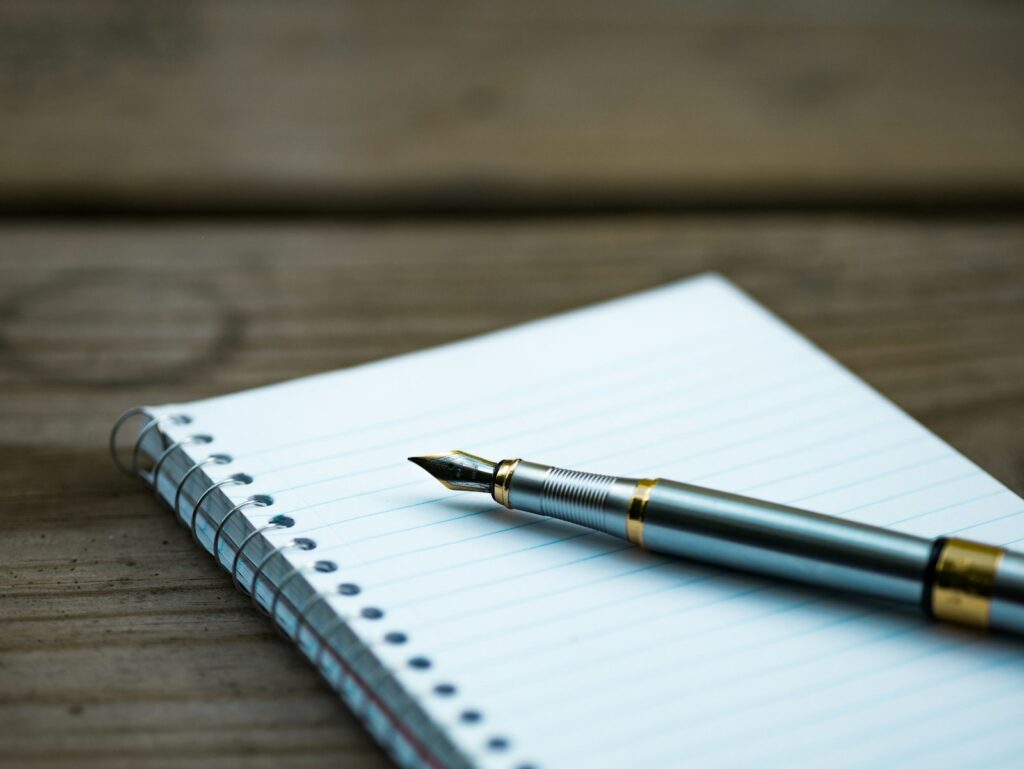 Content Marketing: Füllfederhalter auf einem Notizbuch als Symbol für das Schreiben von Inhalten