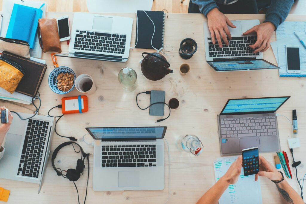 Team arbeitet an einem Tisch mit Laptops